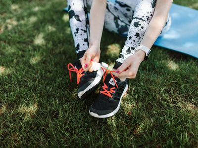 Close-up of comfortable sport shoes and a yoga mat.